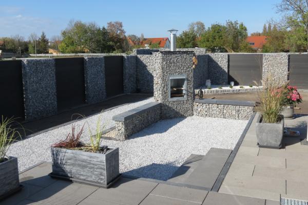 Tuin met schanskorven en haard